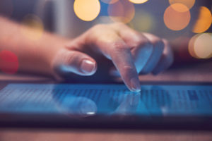 A person scrolls through news on an ipad