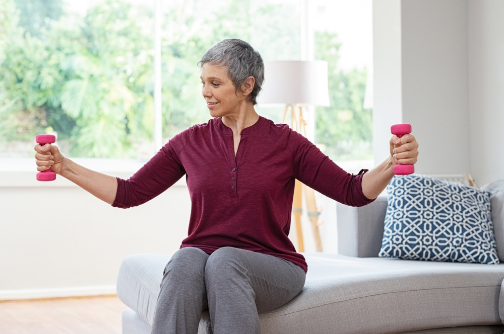 Elderly woman uses weights for exercise